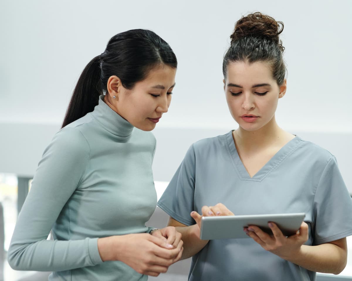 Zwei Fachkräfte im Gespräch mit Tablet
